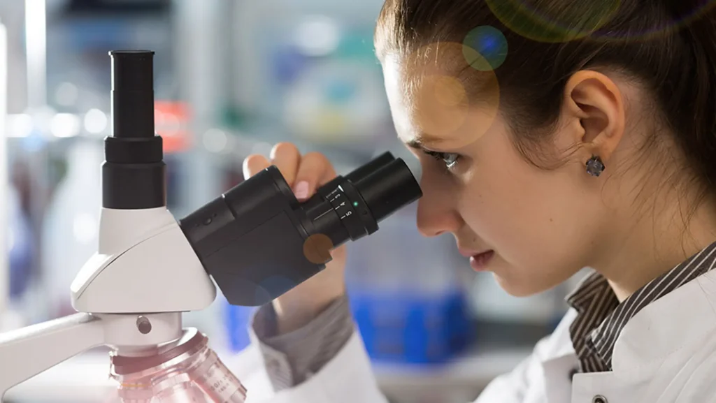 Photo of a woman at a microscope